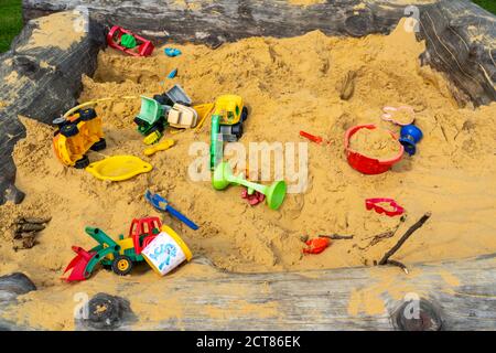 Sandpit, on a children's playground, sandpit with various toys made of plastic, excavator, shovels, molds Sauerland, NRW, Germany Stock Photo