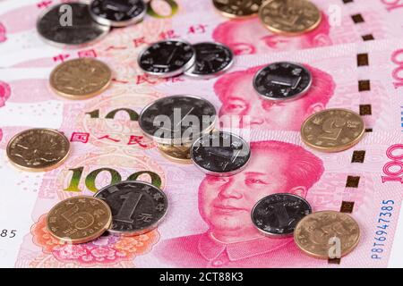 Collage of New Chinese 100 RMB or Yuan featuring Chairman Mao on the front of each bill and Chinese coins Stock Photo