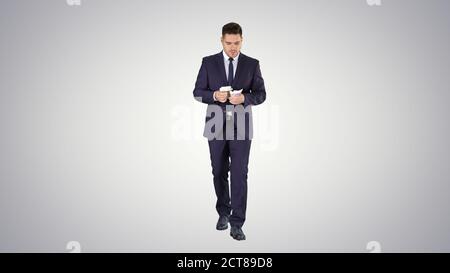 Man in suit walking and counting money on gradient background. Stock Photo