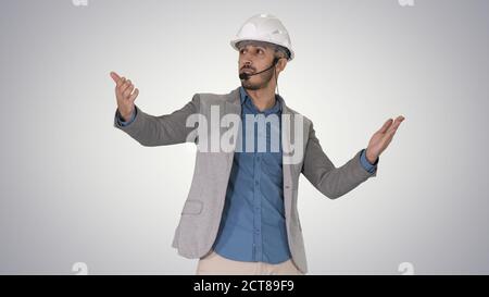 Architect man in helmet and head set talking to camera and makin Stock Photo