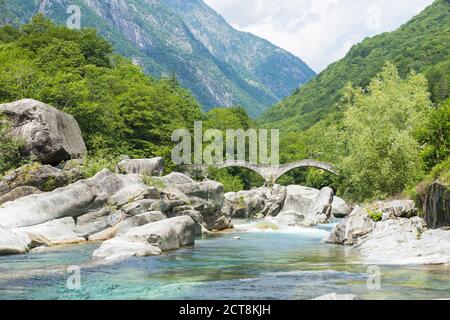 River in Valley Verzasca and Bridge Ponte dei Salti with Mountain in a Sunny Day in Ticino, Switzerland. Stock Photo