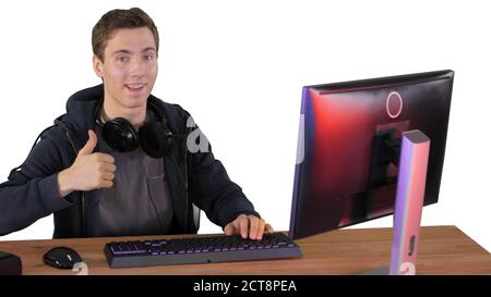 Gamer guy with headphones playing video games on computer and sh Stock Photo