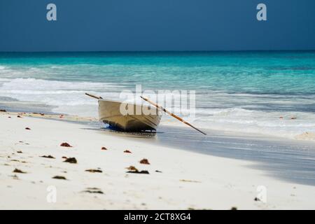 Small boat on beach shore with storm in background Stock Photo