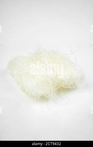 uncooked dry glass noodle, white bean asian vermicelli, rice noodles, isolated on white Stock Photo