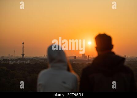 Berlin, Germany. 22nd Sep, 2020. Two people are watching the sunrise over Berlin on the Drachenberg. Credit: Christophe Gateau/dpa/Alamy Live News