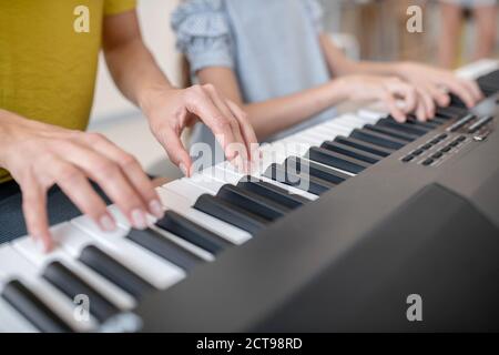 Close up picture of two people playing piano together Stock Photo