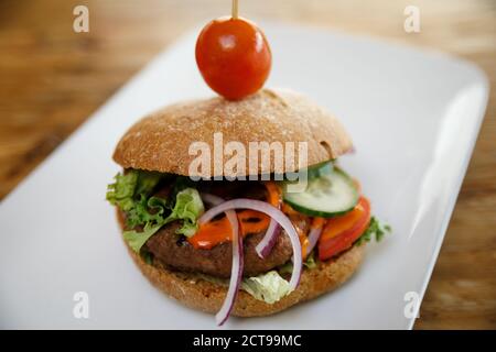 A burger isolated on a white plate with negative space. Stock Photo