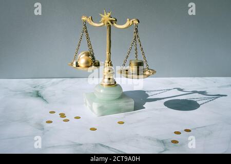 Cost of Christmas holidays concept. Weight scales, vintage gilded balance with stack of coins and Xmas trinkets. Stock Photo