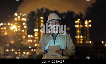 Industrial engineer talking to camera and looking up info in tab Stock Photo