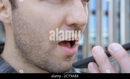 Casual man using the voice recognition on the phone, audio messa Stock Photo