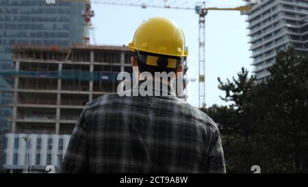 Employee male warehouse worker engineer man in hard hat walking Stock Photo