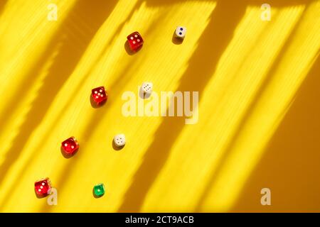 Dice diagonal on a yellow background, beautiful light and shadows. Playing a game with dice. Rolling the dice concept for business risk. Stock Photo