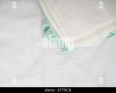 A stack of warm knitted things on a white bed. Cozy clothes. Household concept. folded knitted things white Stock Photo
