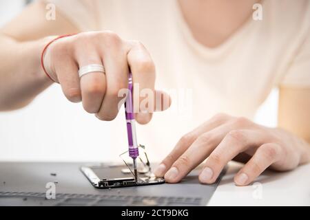Technician worker repair faulty phone and battery in technology mobile service. Concept recycle cellphone device Stock Photo