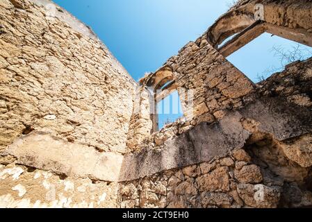 Old ruined and abandoned building with stone walls under blue sky. High quality photo Stock Photo