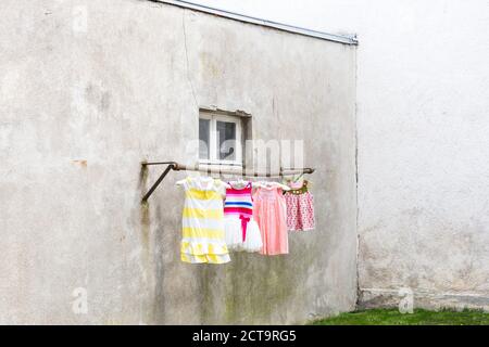 Germany, glum backyard with children's dresses hanging on clothes pole Stock Photo
