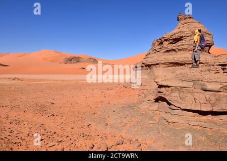 Algeria, Sahara, Tassili N'Ajjer National Park, Woman standing on rock in Tin Merzouga Stock Photo