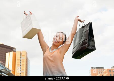 Germany, Berlin, Potsdam Square, happy young woman with two shopping bags Stock Photo