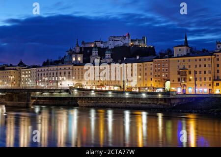 Austria, Salzburg State, Salzburg, Hohensalzburg Castle with old town and towers of Salzburg Cathedral, Salzach River in the evening Stock Photo