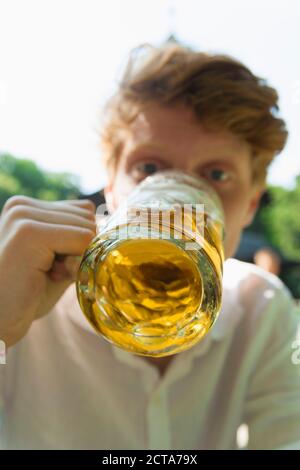 Young man drinking beer outdoors Stock Photo