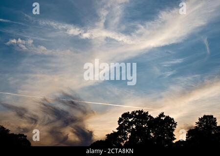 Rich blue evening sky full of wispy clouds and an orange horizon Stock Photo