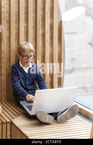 Concentrated boy in glasses gazing at the computer screen Stock Photo