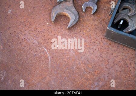 Old wrenches on a rusty sheet of metal, close-up, selective focus Stock Photo