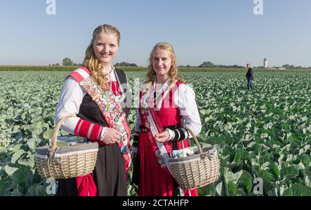 22 September 2020, Schleswig-Holstein, Dithmarschen (kreis): This year's cohregentesses of the Dithmarschen district, Hepke I. (l) and Fenja I, stand on a cabbage field. Dithmarschen, the largest closed cabbage growing area in Europe, celebrates cabbage for a week with the Dithmarscher Kohltage. The days are opened with the traditional cabbage cutting by the district president and minister of agriculture. Photo: Markus Scholz/dpa Stock Photo