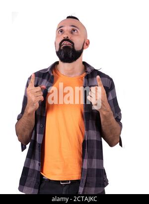 Surprised young hispanic man pointing and looking up Stock Photo