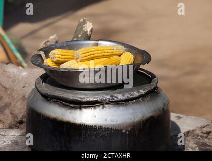 ELLA, SRI LANKA - AUGUST 27: Cooking and selling corn on the street in Sri Lanka. Street food cooking and selling is very popular among locals Stock Photo