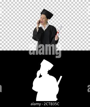 Happy female student in graduation robe talking emotionally on t Stock Photo