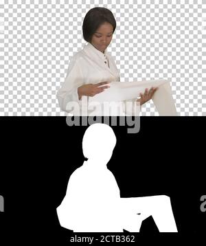 Smiling african american female doctor reading cardiogram, Alpha Stock Photo