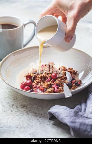 Vegan breakfast - baked oatmeal with berries and oat milk in a white bowl. Stock Photo