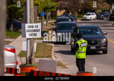 London, Canada - Sept, 21, 2020. Cars line up waiting upwards of three hours to be seen by public health screening nurses before proceeding for a COVI Stock Photo