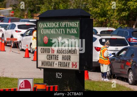 London, Canada - Sept, 21, 2020. Cars line up waiting upwards of three hours to be seen by public health screening nurses before proceeding for a COVI Stock Photo