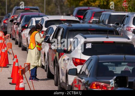 London, Canada - Sept, 21, 2020. Cars line up waiting upwards of three hours to be seen by public health screening nurses before proceeding for a COVI Stock Photo