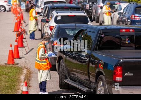 London, Canada - Sept, 21, 2020. Cars line up waiting upwards of three hours to be seen by public health screening nurses before proceeding for a COVI Stock Photo