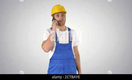 Construction Worker On Telephone on gradient background. Stock Photo