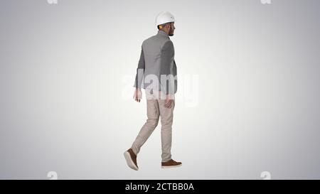 Arabian engineer with hardhat walking Safety concept on gradient Stock Photo