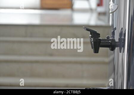 Faucet. in black plastic, in aluminum water cooler in company office, with selective focus and blurred background, side view, Brazil, South America Stock Photo