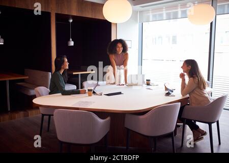 Three Businesswomen Having Socially Distanced Meeting In Office During Health Pandemic Stock Photo