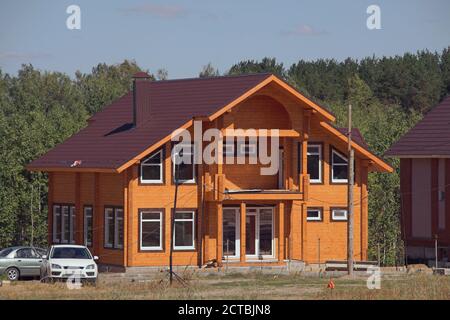 Facade of an unfinished two-story house with no red brick windows