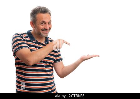 Trustworthy white adult male wearing stylish casual summer striped tshirt pointing index finger at blank copyspace in palm isolated on studio backgrou Stock Photo