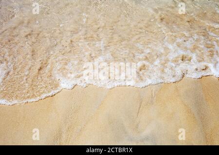 Beach and clear ocean waves top view. Soft sea waves on sunny sandy shore Stock Photo