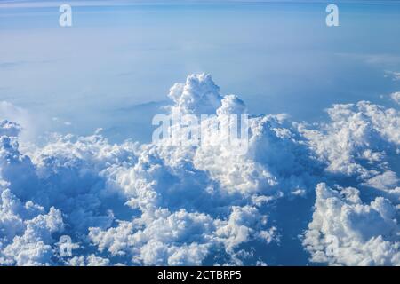 Cumulus storm clouds in blue sky. Beautiful summer landscape with cloudy skyline, aerial view from flying airplane window Stock Photo