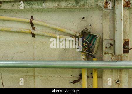 Closeup uncovered electrical junction box, showing cables connected by electrical tape inside the box Stock Photo