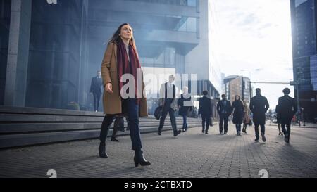 Shot of Young Smart Casually Dressed Female Office Manager Commute to Work in the Morning or from Office on a Sunny Day on Foot. In the Background Stock Photo
