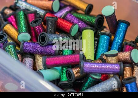 rolls with metallic threads in plastic container  in assortment for craft Stock Photo