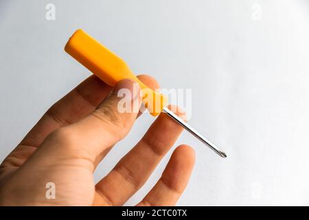 man of man that hold a screwdriver with handle rubber of red color on the white background Stock Photo