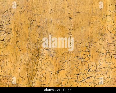 Corroded metal background. Rusted yellow painted metal wall. Rusty metal background with streaks of rust. Rust stains. The metal surface rusted spots. Stock Photo